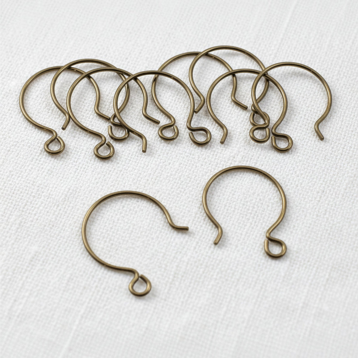 Hackberry Creek antique brass niobium circle hoop ear wires for hypoallergenic jewelry making on white fabric