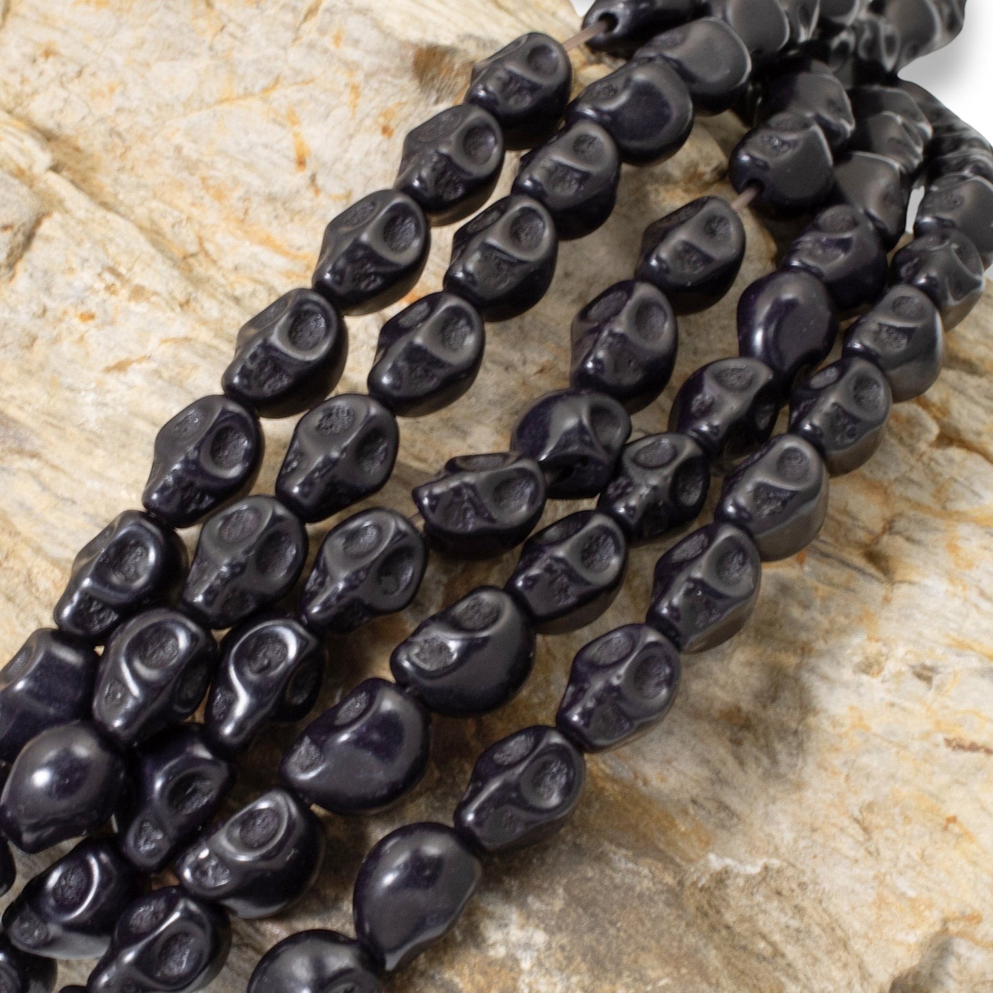 Hackberry Creek black magnesite skull beads on a 15-inch strand for DIY jewelry and Halloween crafts.