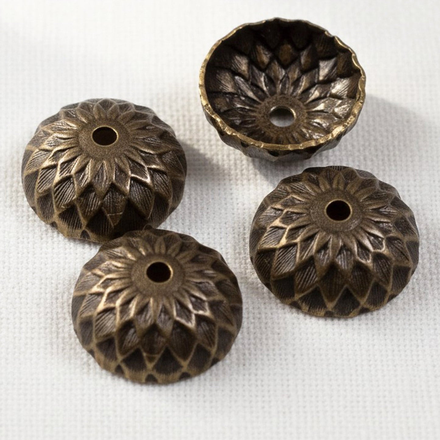 Hackberry Creek 13mm natural brass acorn bead caps with detailed sunflower relief stamping in a rich brown finish.