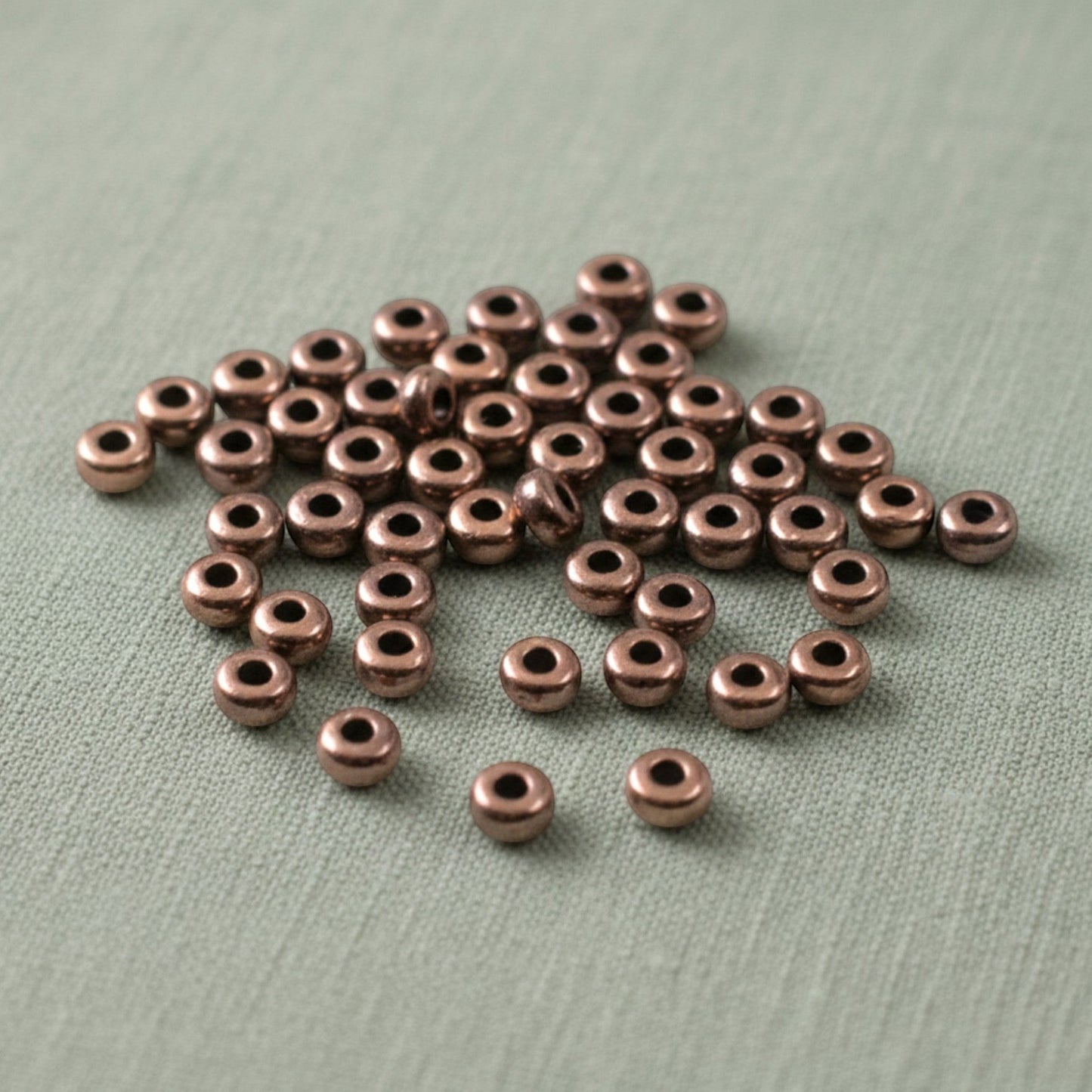 Hackberry Creek 50 copper antique 3mm smooth heishi disk spacer beads for jewelry making.