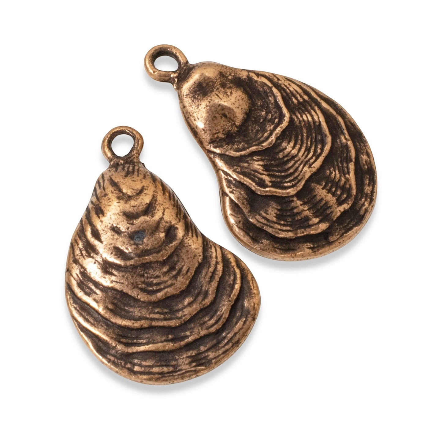 Hackberry Creek antique copper oyster shell charms with detailed ridges, perfect for coastal jewelry designs.