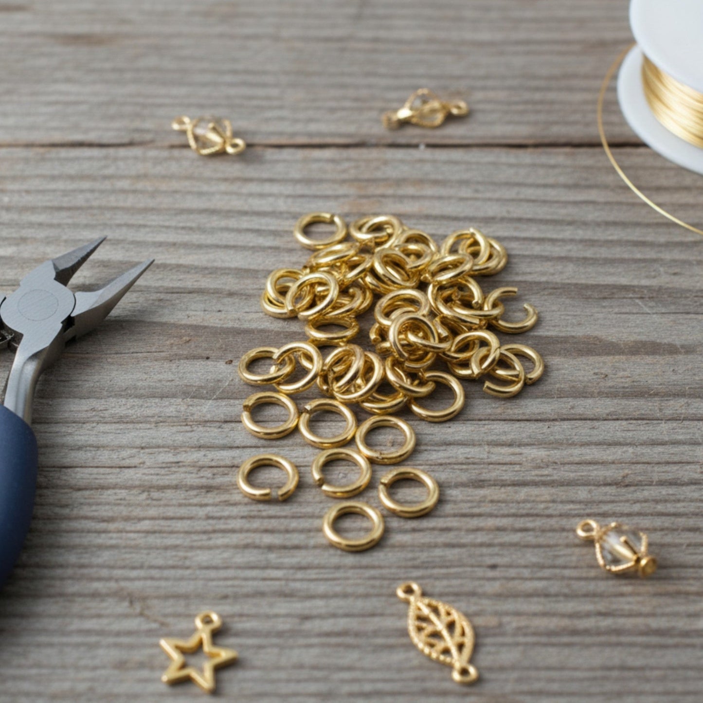 Hackberry Creek 8mm bright gold jump rings made of heavy-duty 15ga 304 stainless steel on a rustic wooden surface.