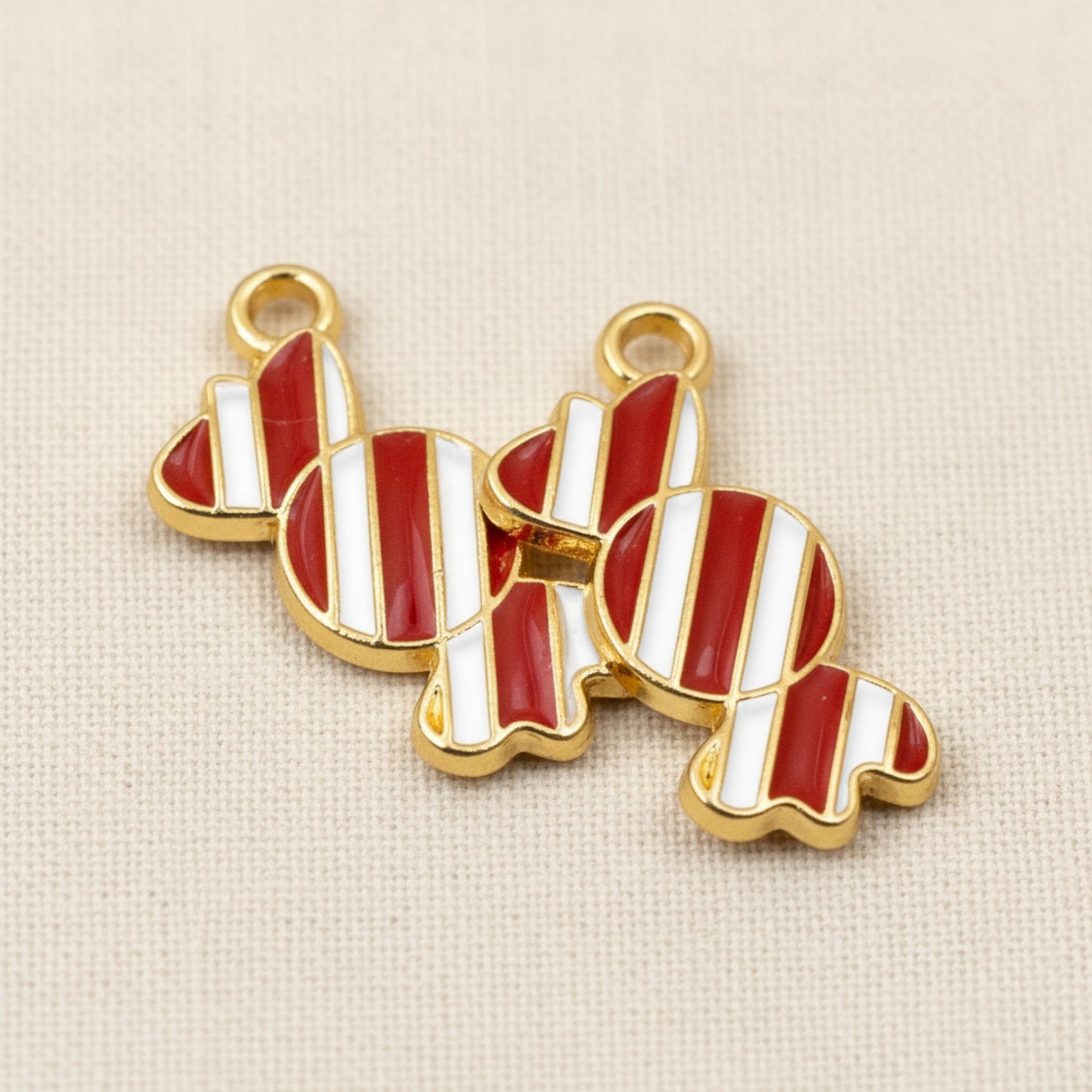 Hackberry Creek peppermint candy charms with red and white enamel stripes and gold-plated metal backing for crafts.