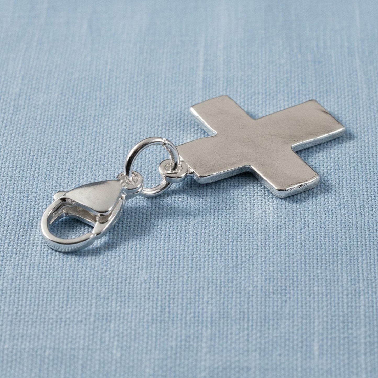Hackberry Creek silver-plated cross charm with a stainless steel lobster clasp for bags or jewelry.
