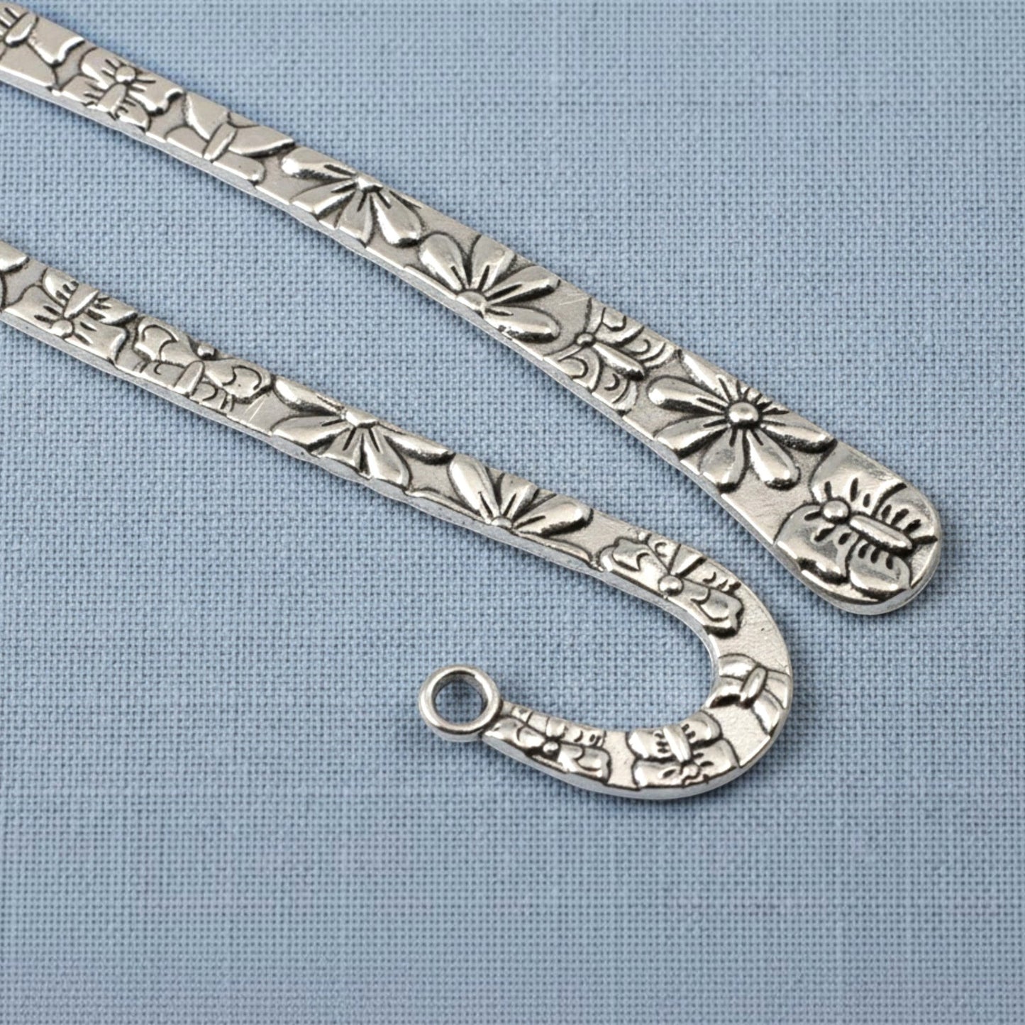 Hackberry Creek silver zinc alloy hook bookmarks with raised floral and butterfly patterns for DIY jewelry projects.