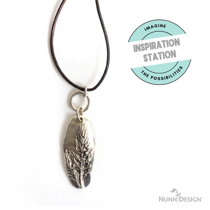 Hackberry Creek antique silver Denali pine tree pendant on a dark leather cord for a rustic woodland jewelry design.