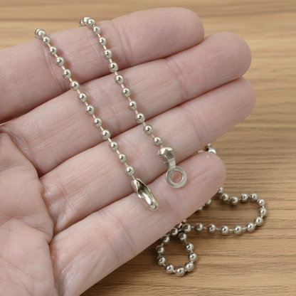Hackberry Creek nickel-plated steel ball chain for DIY ceiling fan pulls held in a hand against a wood background