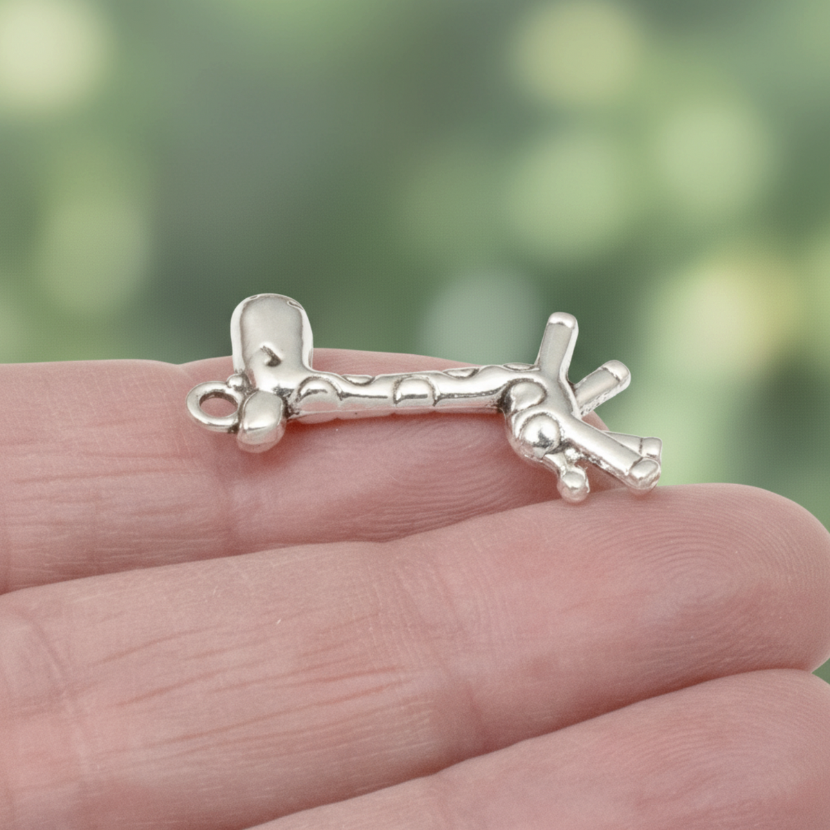 Hackberry Creek antique silver giraffe charm held in hand, featuring a detailed 3D metal alloy design for jewelry.