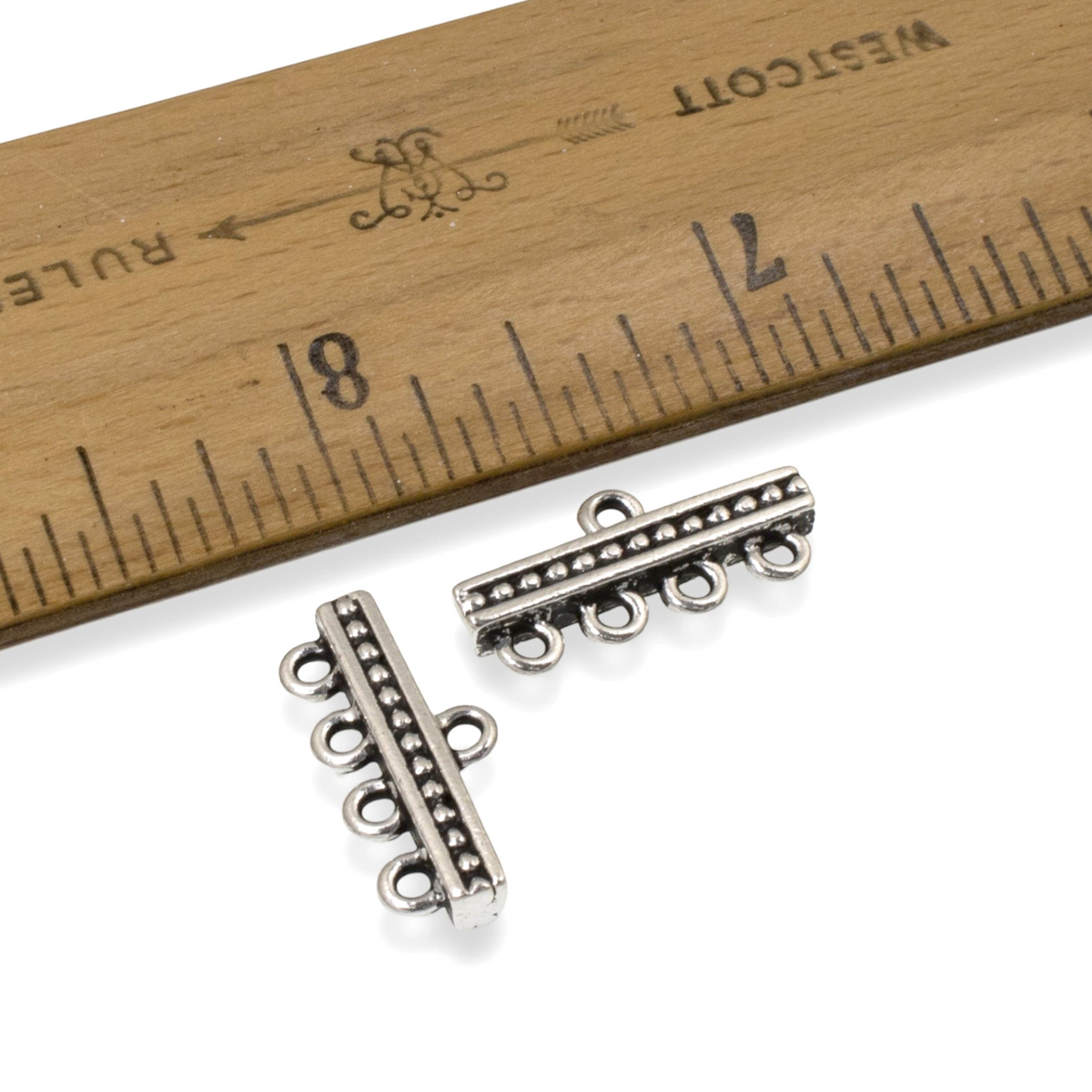 Hackberry Creek antique silver-plated 4-to-1 beaded connector links for multi-strand jewelry next to a wooden ruler.