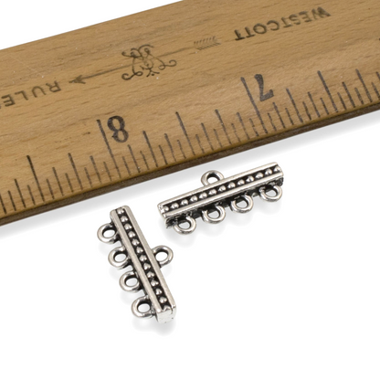 Hackberry Creek antique silver-plated 4-to-1 beaded connector links for multi-strand jewelry next to a wooden ruler.