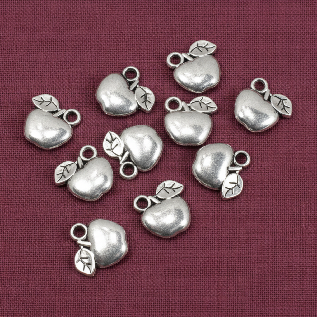 Hackberry Creek silver apple charms for jewelry making, crafted from zinc alloy with a shiny metallic finish.