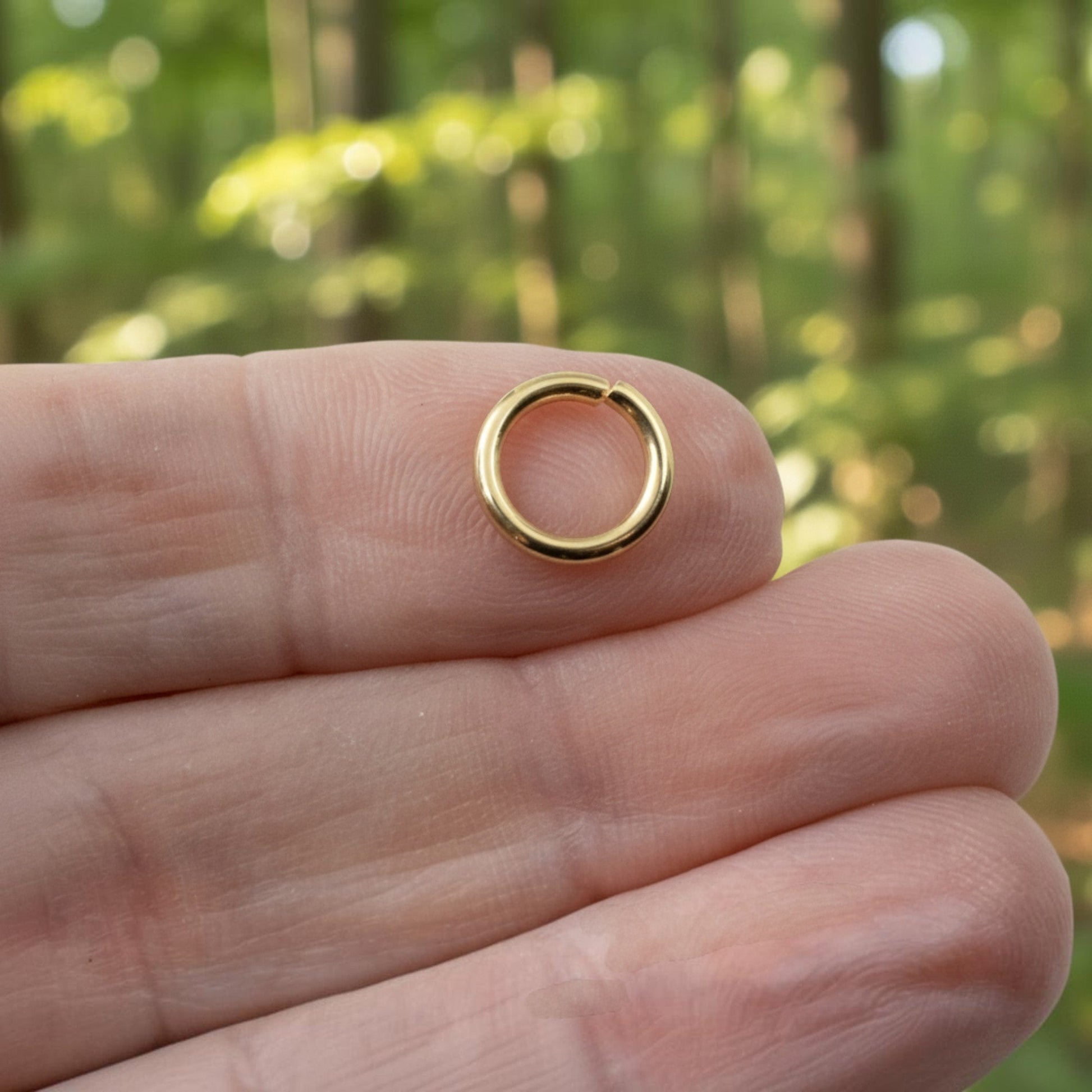 Hackberry Creek 10mm bright gold jump ring made of 15 gauge 304 stainless steel held on a finger