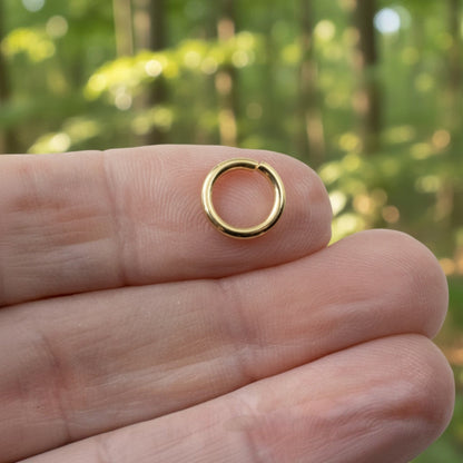 Hackberry Creek 10mm bright gold jump ring made of 15 gauge 304 stainless steel held on a finger