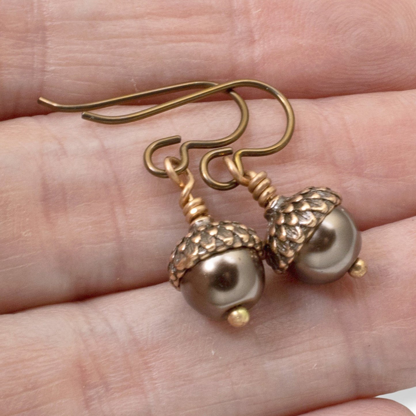 Hackberry Creek brown glass pearl and copper acorn cap earrings with hypoallergenic niobium hooks.