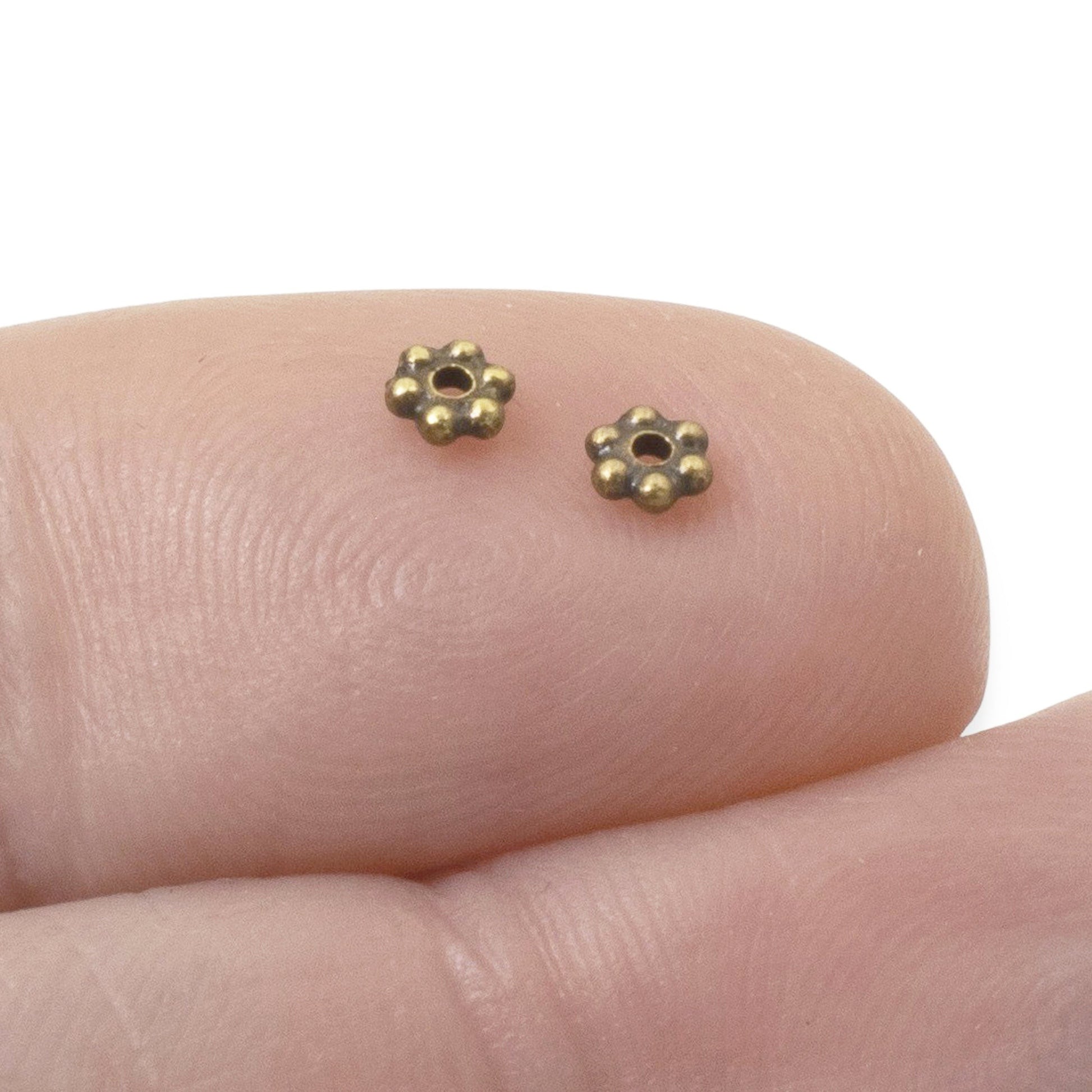 Hackberry Creek 50 antique brass 3mm daisy spacer beads made of lead-free pewter. Tiny flower-shaped beads for jewelry making.