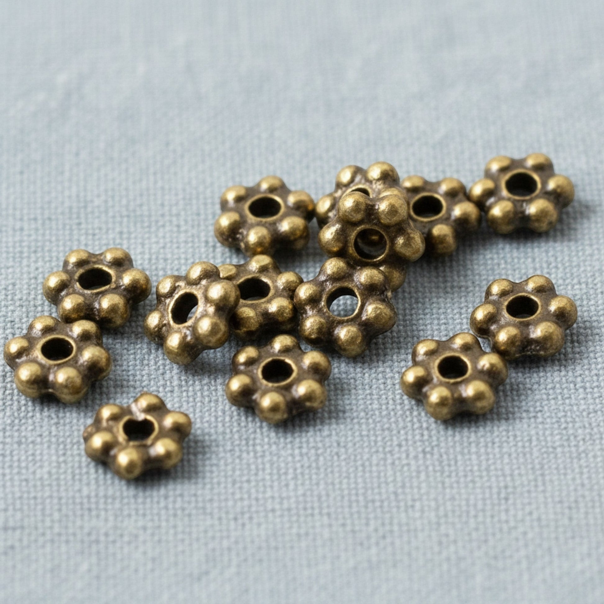 Hackberry Creek 50 antique brass 3mm daisy spacer beads made from lead-free pewter. Tiny jewelry beads with a rich patina.