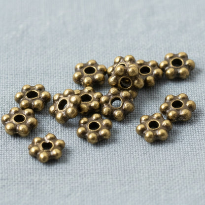 Hackberry Creek 50 antique brass 3mm daisy spacer beads made from lead-free pewter. Tiny jewelry beads with a rich patina.