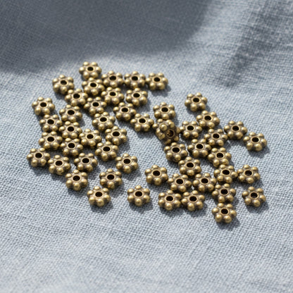 Hackberry Creek 50 antique brass 3mm daisy spacer beads made of lead-free pewter with a heishi shape.
