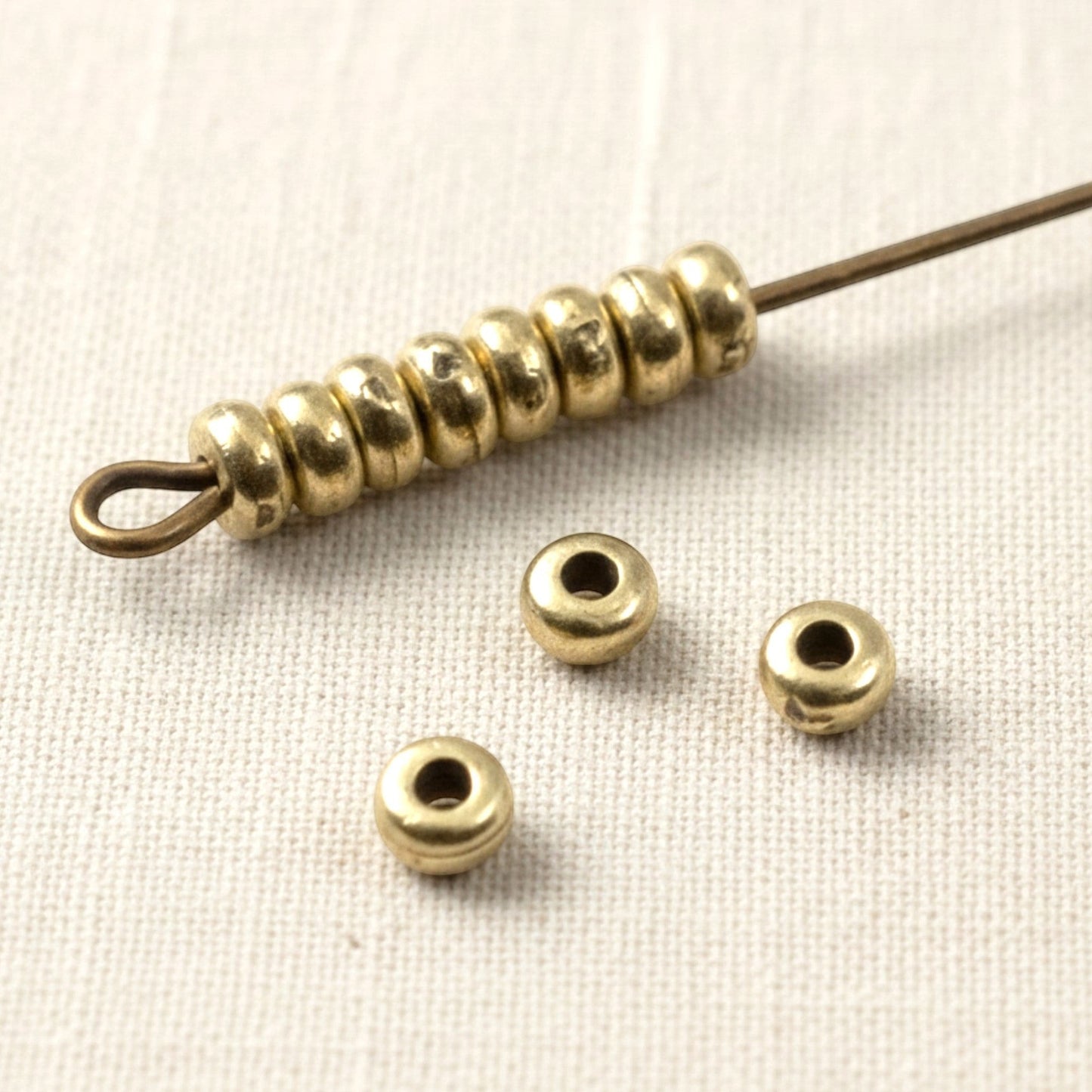 Hackberry Creek Antique Brass 3mm smooth heishi disk beads for boho jewelry making. Pack of 50.