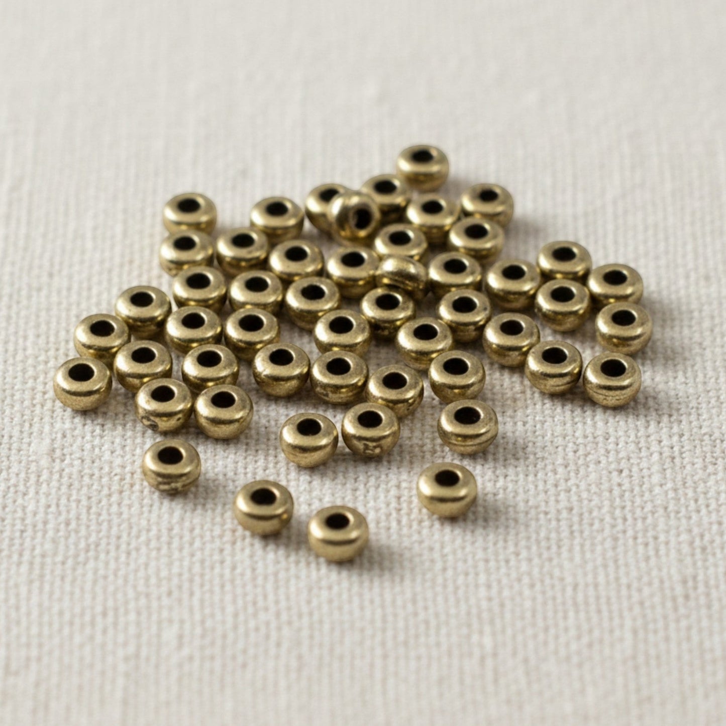 Hackberry Creek Antique Brass 3mm smooth heishi disk beads, 50 pack, boho style jewelry making.