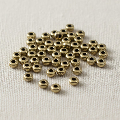 Hackberry Creek Antique Brass 3mm smooth heishi disk beads, 50 pack, boho style jewelry making.