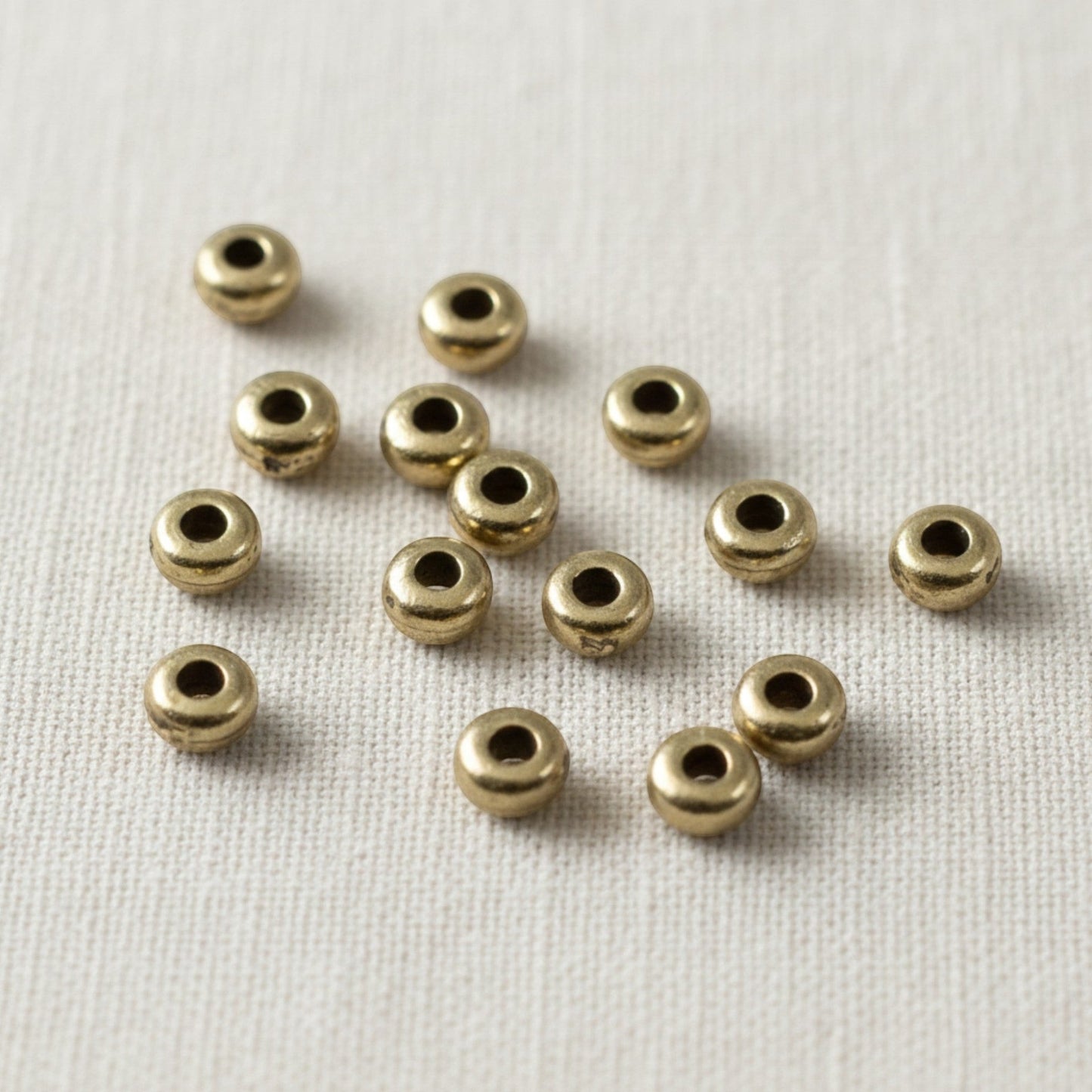 Hackberry Creek Antique Brass 3mm smooth heishi disk beads for boho jewelry design. Pack of 50.