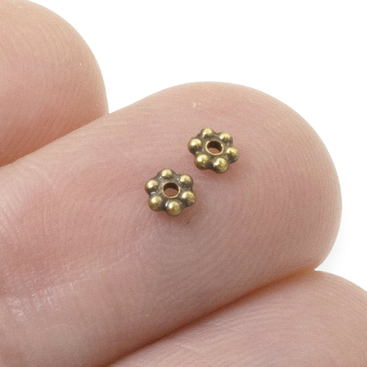 Hackberry Creek 50 antique brass 3mm daisy spacer beads made of lead-free pewter with a .5mm hole for jewelry making.