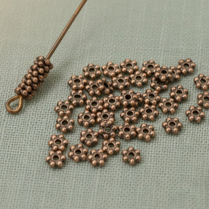 Hackberry Creek 50 antique copper 3mm daisy spacer beads, designed by TierraCast, made from lead-free pewter with copper plating.