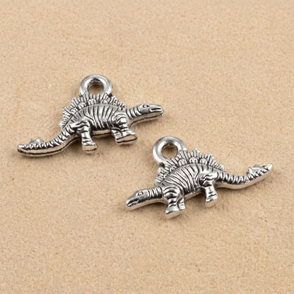 Hackberry Creek antique silver metal dinosaur charms for jewelry making, featuring detailed double-sided designs.