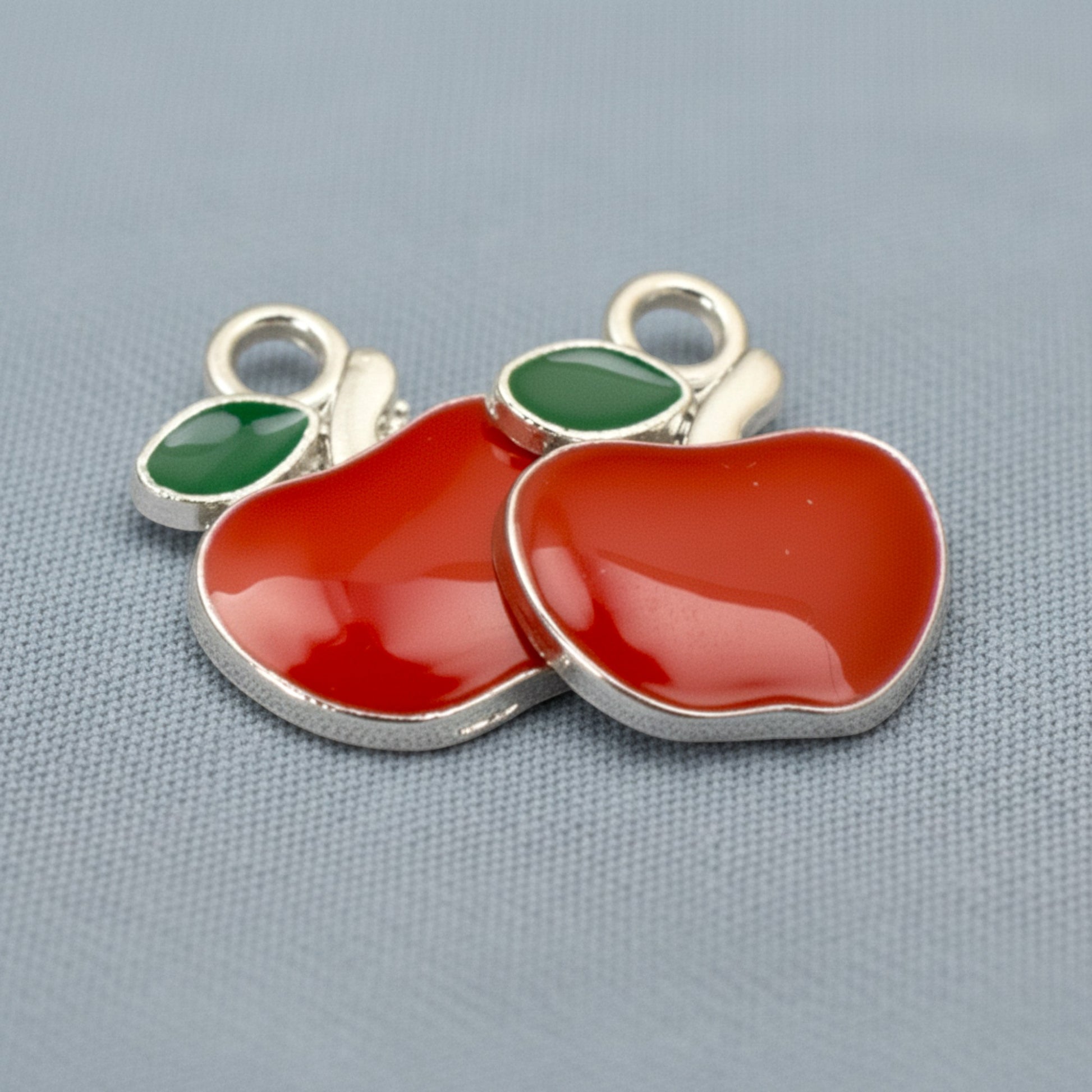 Hackberry Creek 6-pack of bright red enamel apple charms with green leaves and silver loops for jewelry making.
