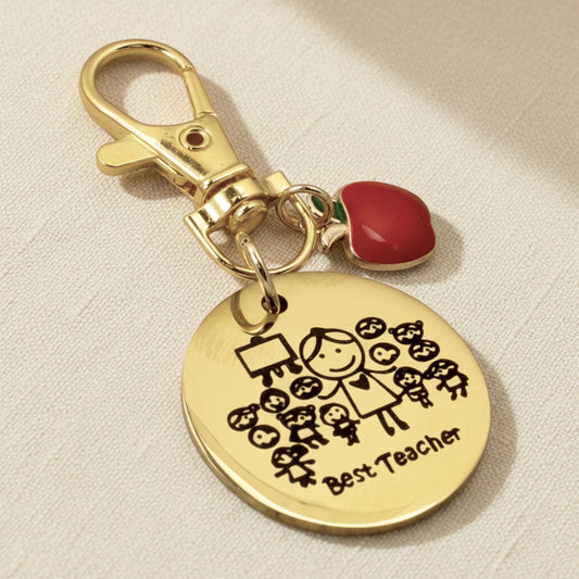 Hackberry Creek gold stainless steel Best Teacher bag charm with an enamel apple and engraved teacher illustration.