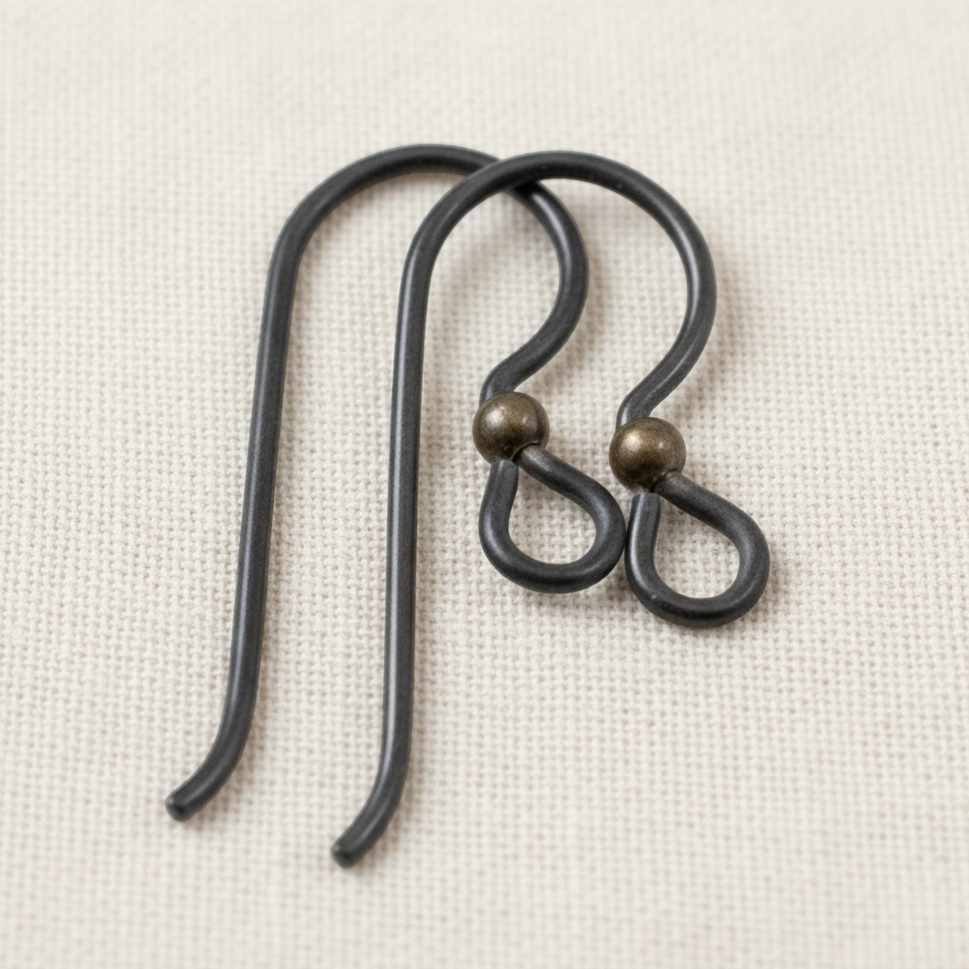 Hackberry Creek matte black niobium earring hooks with antique brass bead, 10 pack, for sensitive ears and vintage boho styles.