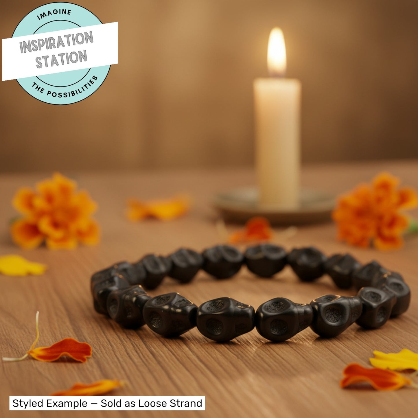 Hackberry Creek black magnesite skull beads arranged in a circle on a wooden table with marigolds and a lit candle.