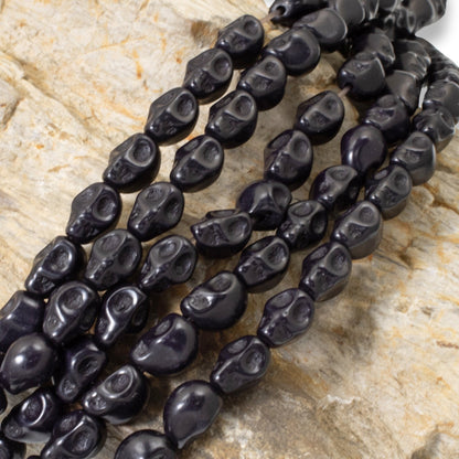 Hackberry Creek black magnesite skull beads on a 15-inch strand for DIY jewelry and Halloween crafts.