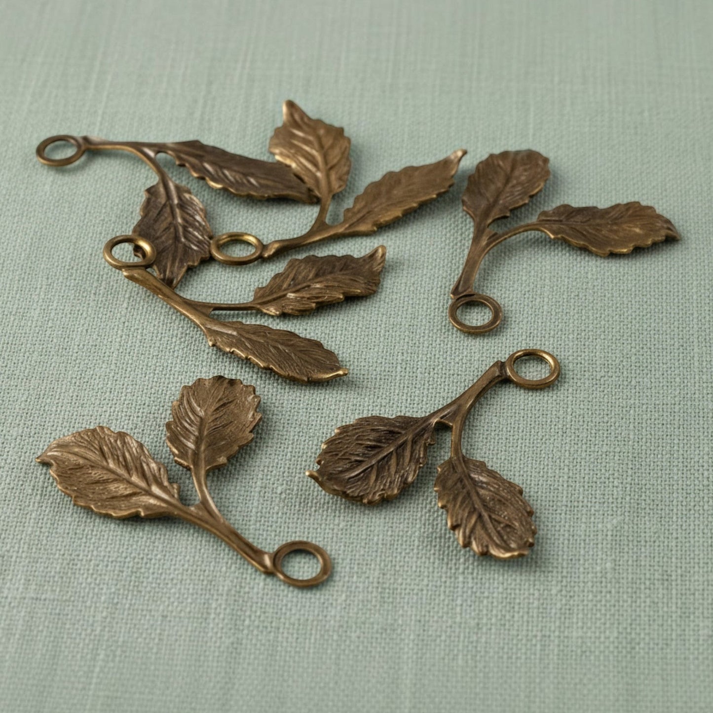 Hackberry Creek antiqued brass beech leaf charms with detailed double-sided botanical texture for jewelry making.