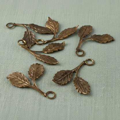 Hackberry Creek antiqued brass beech leaf charms with detailed double-sided botanical texture for jewelry making.
