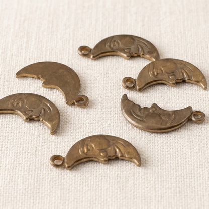 Hackberry Creek antiqued brass Man in the Moon crescent charms with detailed celestial faces for jewelry making.
