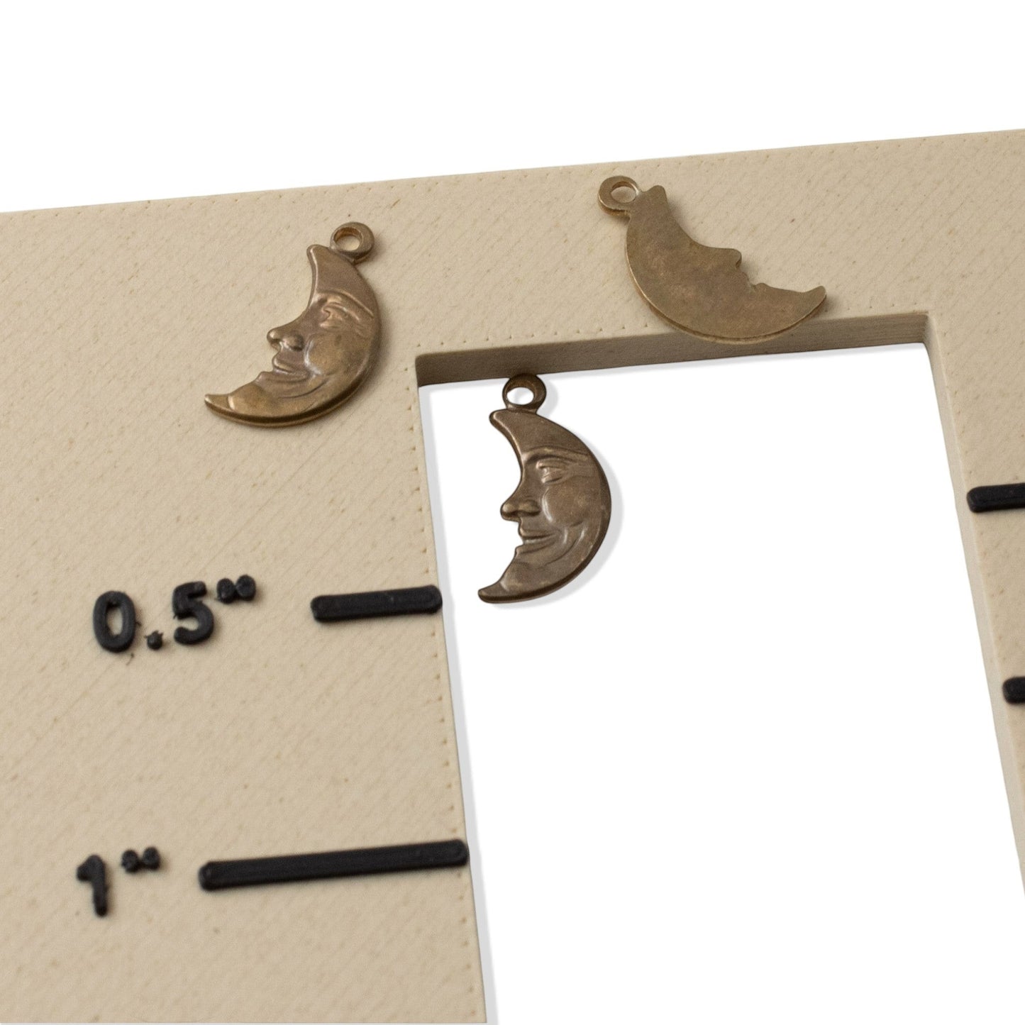 Hackberry Creek antiqued brass Man in the Moon crescent charms for celestial jewelry making on a size guide