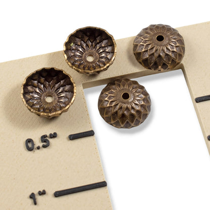 Hackberry Creek 13mm natural brass acorn bead caps with detailed sunflower relief stamping on a measuring card.