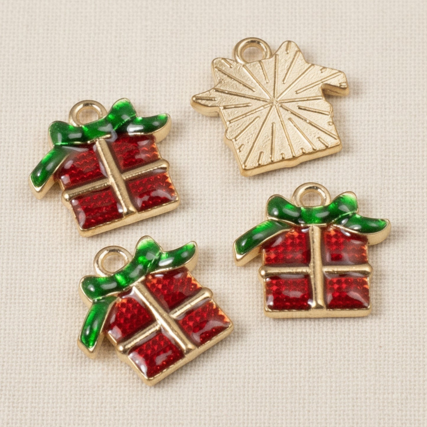 Hackberry Creek Christmas present charms with red enamel gift boxes and green bows, featuring gold-plated metal backs.