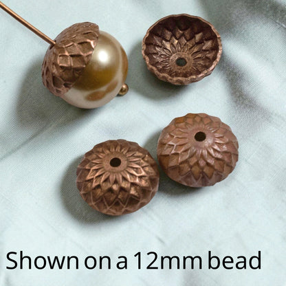 Hackberry Creek artisan copper acorn bead caps with sunflower petal relief design, shown with a 12mm round bead.