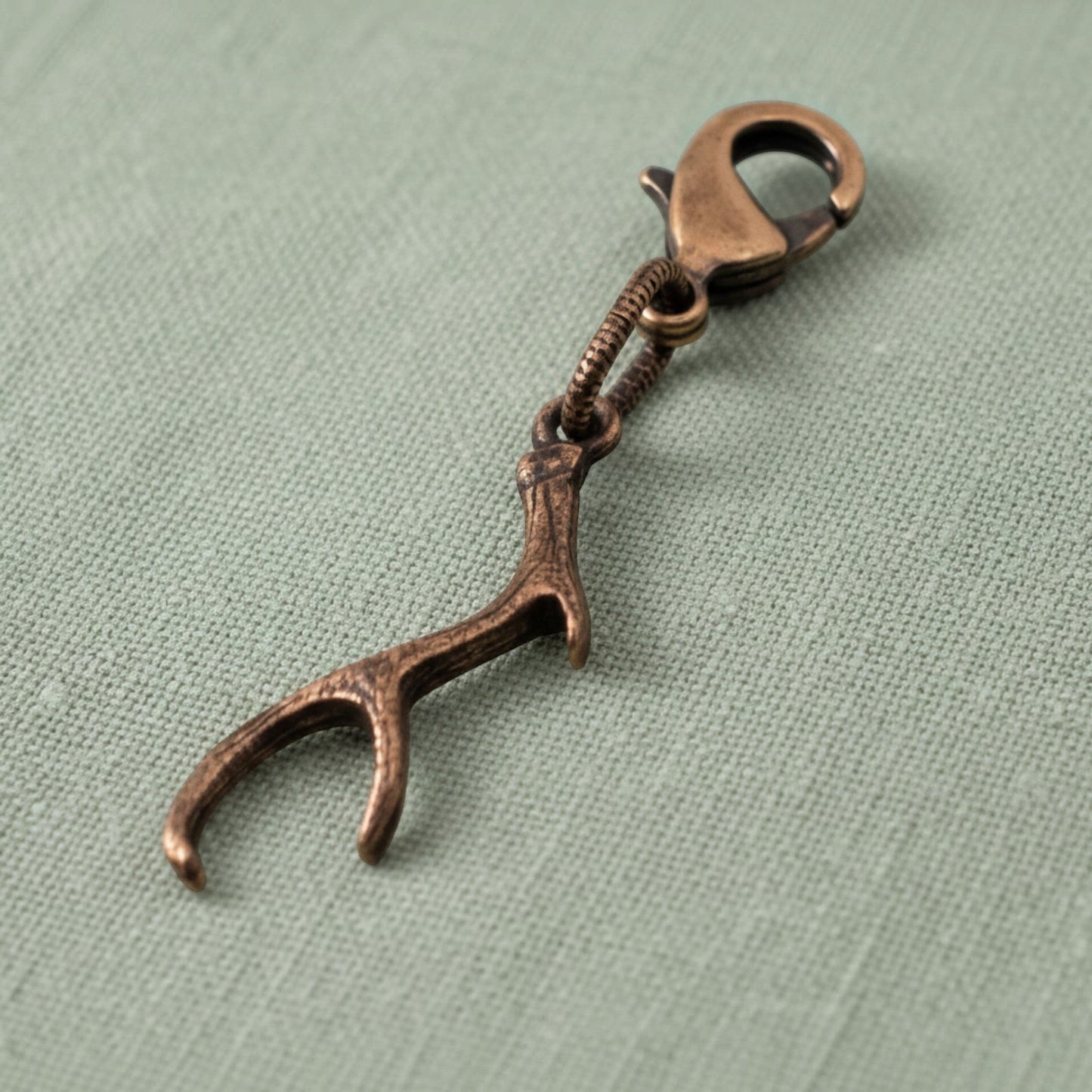Hackberry Creek copper antler charm with a lobster clasp, featuring rustic textured detail for bags or jewelry.