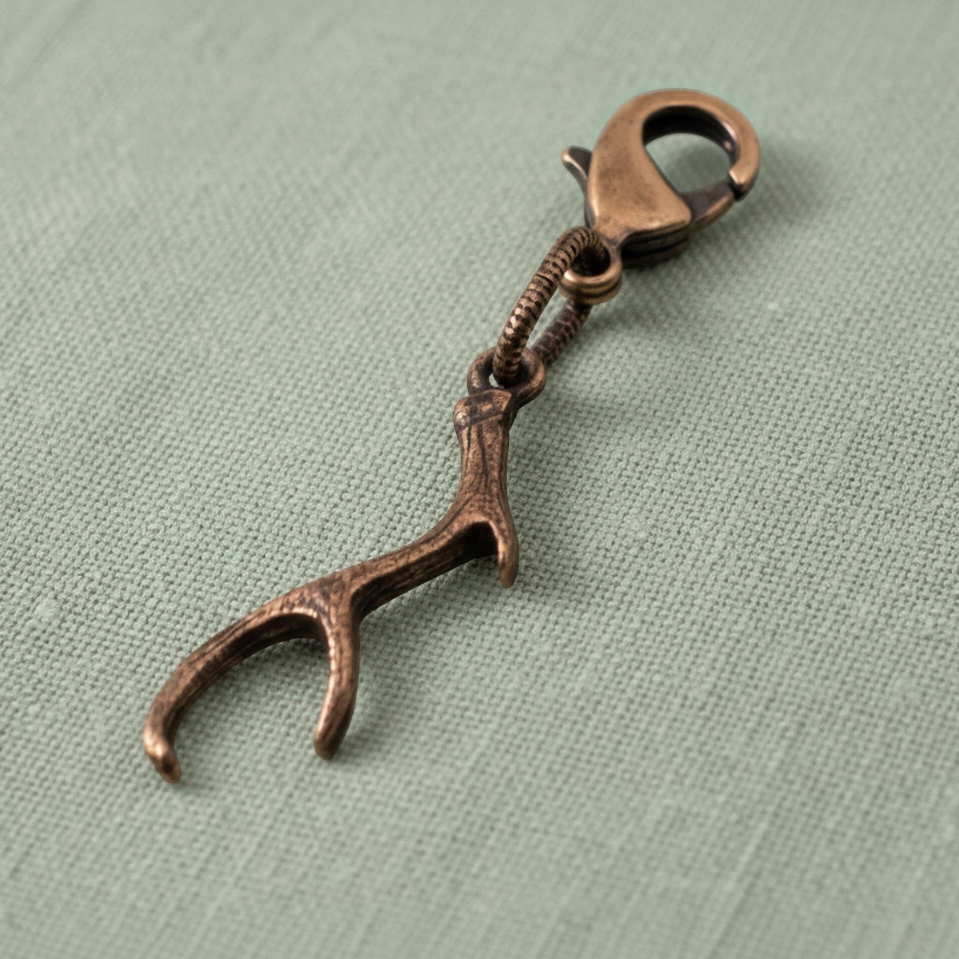 Hackberry Creek copper antler charm with a lobster clasp, featuring rustic textured detail for bags or jewelry.
