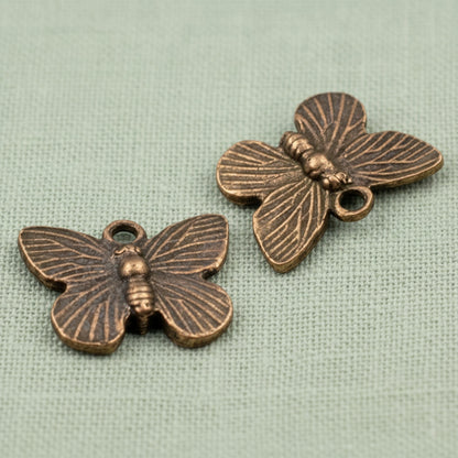 Hackberry Creek antique copper butterfly charms with detailed wing patterns for rustic jewelry making.