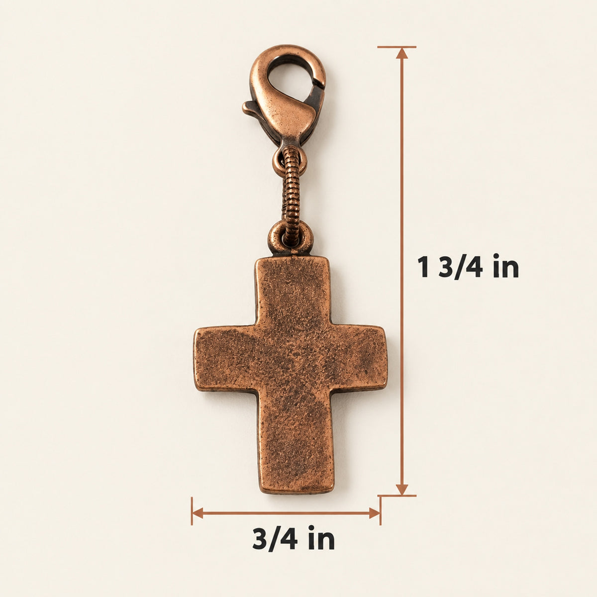 Hackberry Creek copper cross charm with distressed texture and lobster clasp, measuring 1.75 inches in total length.