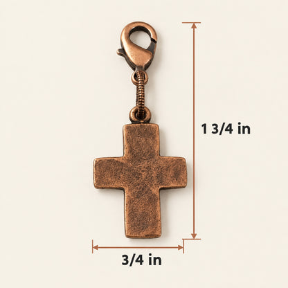 Hackberry Creek copper cross charm with distressed texture and lobster clasp, measuring 1.75 inches in total length.