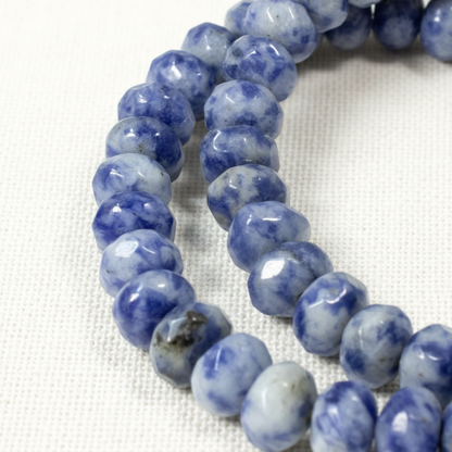 Hackberry Creek faceted denim lapis rondelle beads in blue and gray on a white background