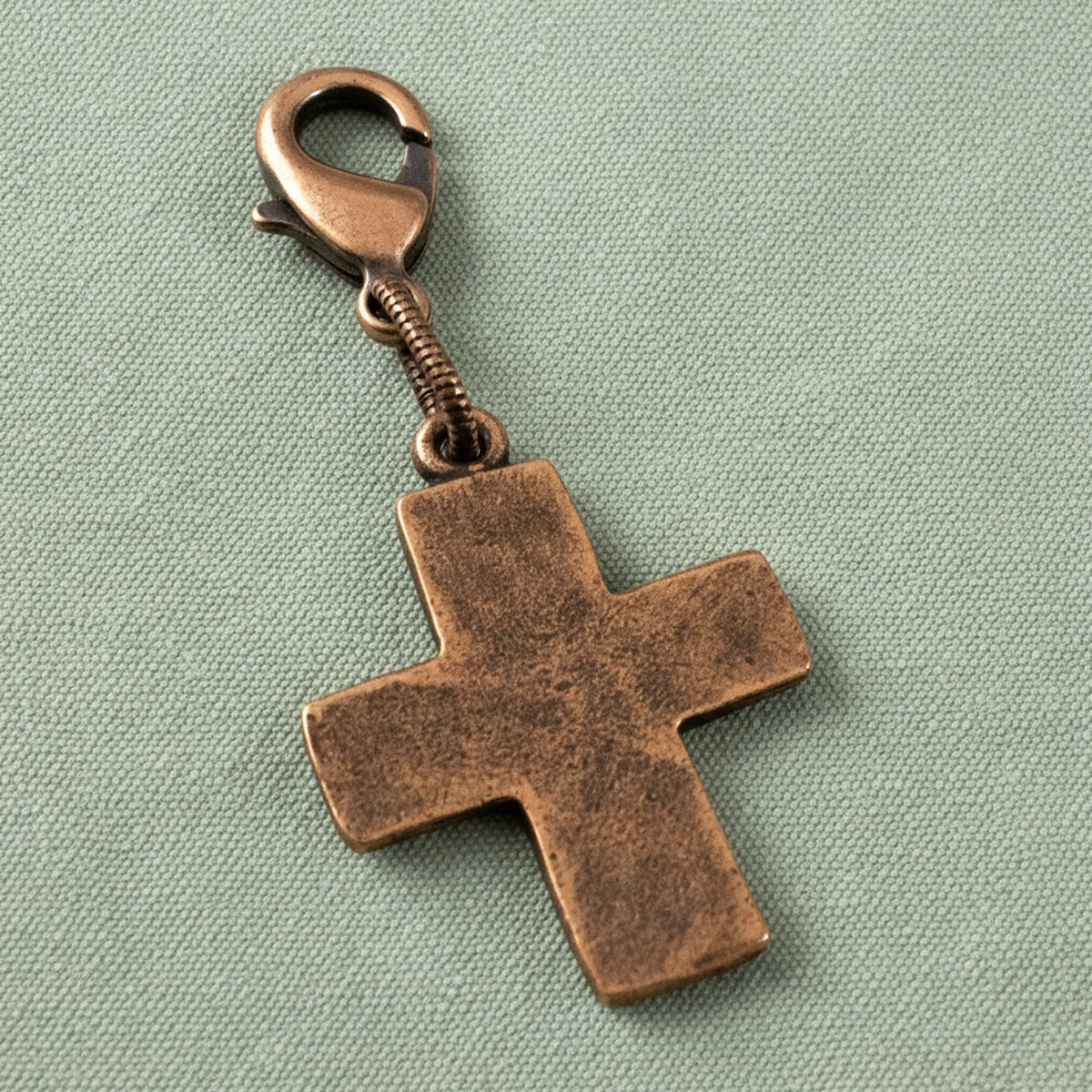 Hackberry Creek distressed copper cross charm with a lobster clasp for bags, bracelets, or zipper pulls.