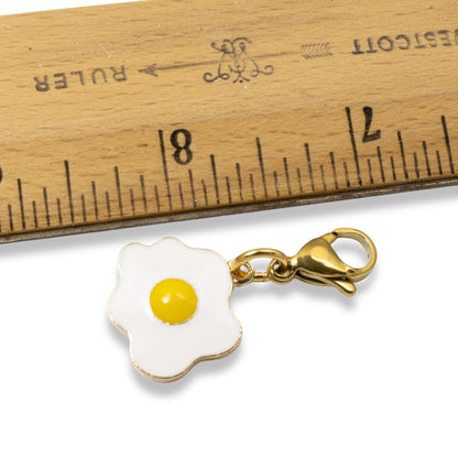 Hackberry Creek enamel fried egg charm with a gold-plated lobster clasp, shown next to a ruler for size reference.