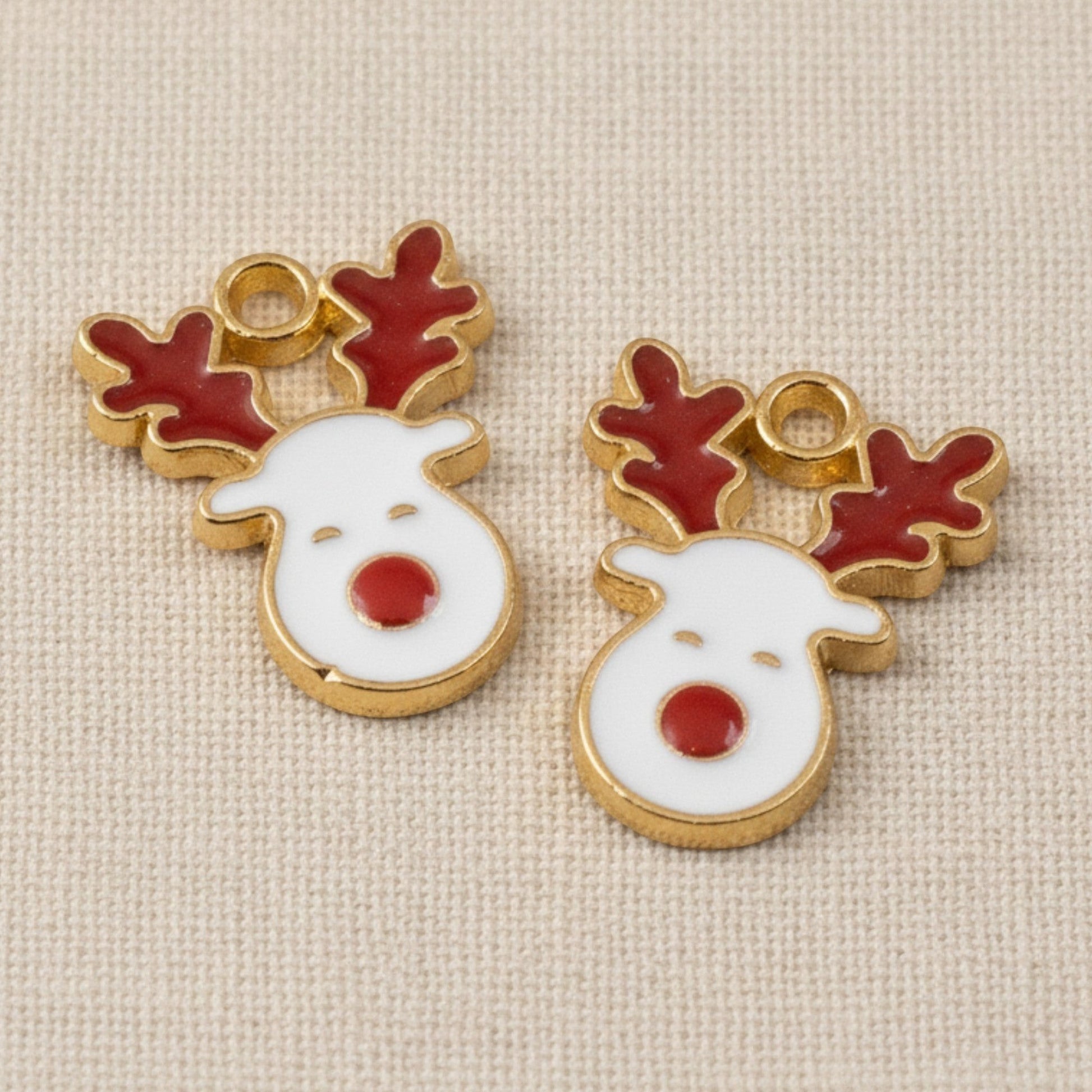 Hackberry Creek gold-plated enamel reindeer charms with white faces, red noses, and red antlers for holiday crafts.
